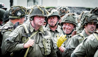 Aziz Michael L 'Eglise, Normandiya, Fransa - 6 Haziran 2023. İkinci Dünya Savaşı anısına. Askeri kamp yeniden yapılandırıldı. Tanımlanamayan silahlı askerler özgürlükten sonra yürüyorlar