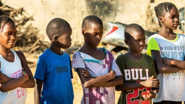 Bour, Senegal - CIRCA Mart 2021. Kimliği belirlenemeyen yoksul Afrikalı çocuklar ve dışarıda oynayan gençler.