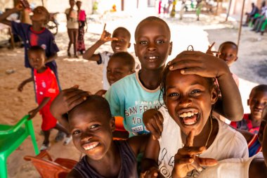 Bour, Senegal - CIRCA Mart 2021. Kimliği belirsiz mutlu, gülümseyen Afrikalı çocuklar ve kameraya bakan gençler..