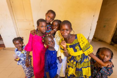 Bour, Senegal - CIRCA Mart 2021. Kimliği belirsiz mutlu, gülümseyen Afrikalı çocuklar ve kameraya bakan gençler..