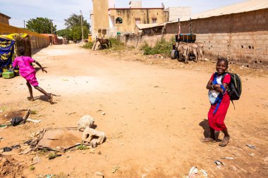Bour, Senegal - CIRCA Mart 2021. Tanımlanamayan ciddi bir şekilde korkmuş fakir Afrikalı çocuklar ve köydeki gençler kameraya bakıyorlardı..