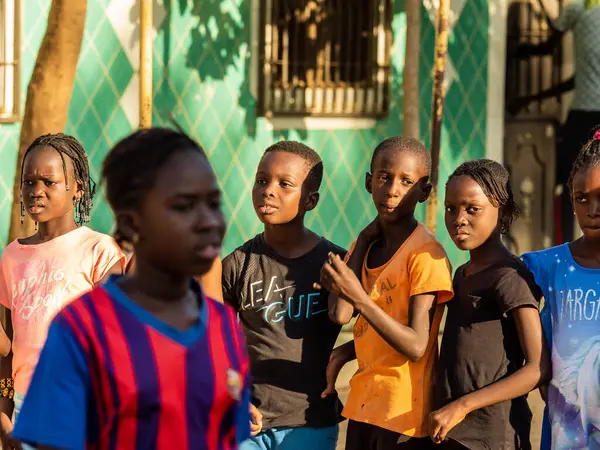 Bour, Senegal - CIRCA Mart 2021. Kimliği belirlenemeyen yoksul Afrikalı çocuklar ve dışarıda oynayan gençler.