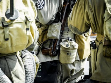 Aziz Michael L 'Eglise, Normandiya, Fransa - 6 Haziran 2023. İkinci Dünya Savaşı anısına. Askeri kamp yeniden yapılandırıldı. Kimliği belirlenemeyen silahlı asker savaş için ağır donanımı kapatıyor.