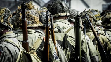 Aziz Michael L 'Eglise, Normandiya, Fransa - 6 Haziran 2023. İkinci Dünya Savaşı anısına. Askeri kamp yeniden yapılandırıldı. Tanımlanamayan silahlı askerler özgürlükten sonra yürüyorlar