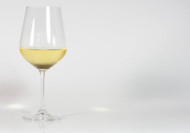 Beyaz arka planda bir bardak beyaz şarap. 