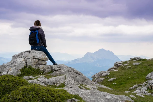 stock image hiker woman on the summit of a mountain looking to the horizon at sunset. High quality photo