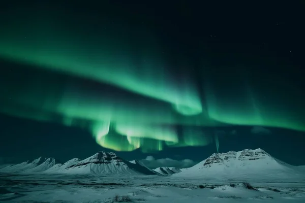 aurora borealis shining in the sky over a snowy landscape in iceland. High quality photo