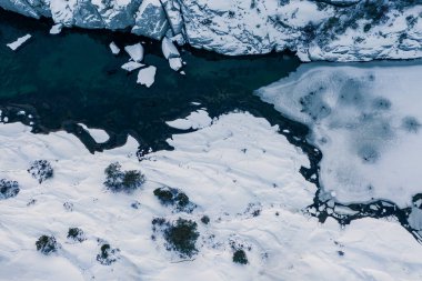 Kışın mavi su ve buz. Havadan insansız hava aracı aşağı bakıyor. Norveç