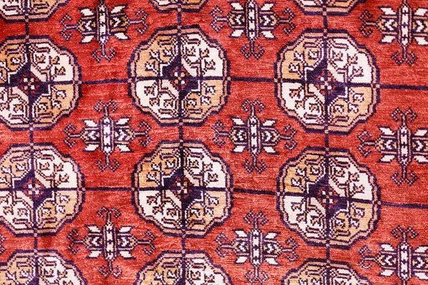 stock image Colorful handmade silk carpet with pattern in red tones, traditional uzbekistan style. Close up.