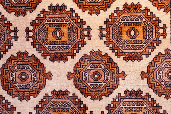 Colorful handmade silk carpet with pattern in red tones, traditional uzbekistan style. Close up.