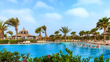 Boa Vista, Cape Verde-22 Mart 2018: Güneşli bir gün Boa Vista 'da palmiye ağaçları, şemsiyeler ve hareketli bir tropikal bar..