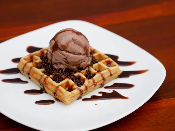 chocolate waffle with ice cream topping and chocolate sprinkles