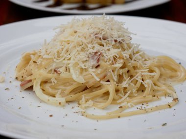 beyaz tabakta peynirli ve biberli spagetti