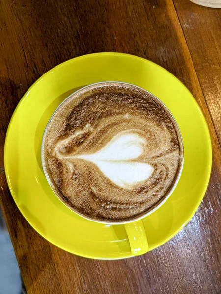 Tahta bir masada bir fincan kahve. en üstteki görünüm