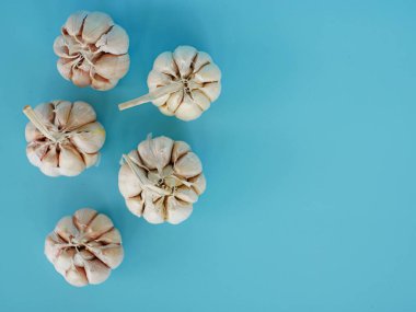 Mavi arkaplanda izole edilmiş sarımsağın üst görünümü