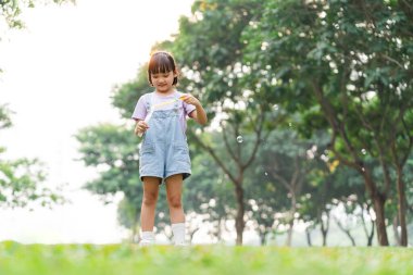 portrait of asian girl playing blowing bubbles