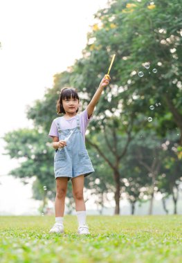 portrait of asian girl playing blowing bubbles