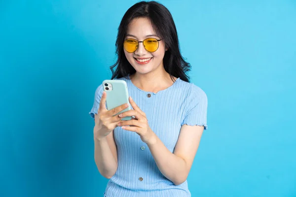 stock image Portrait of smiling asian woman posing on blue background