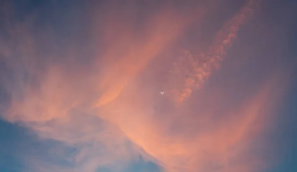 image of orange cloud and moon in dawn