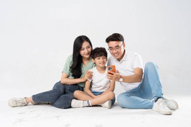 Beyaz bir arkaplanda poz veren bir aile