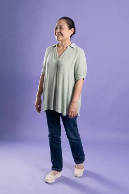 Çete orta yaşlı Asyalı kadın portresi mor arka planda poz veriyor