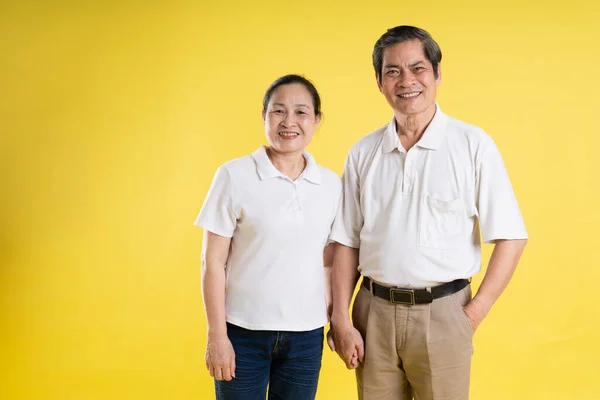 Sarı Arka Planda Poz Veren Orta Yaşlı Asyalı Bir Çiftin — Stok fotoğraf