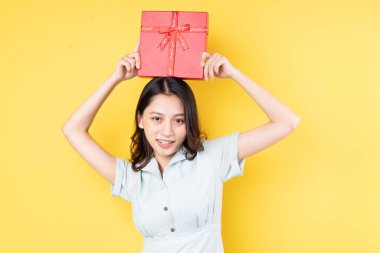 Elinde hediye kutusu olan Asyalı kadının portresi.