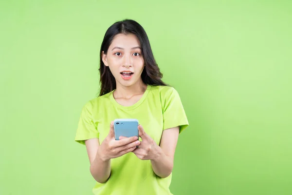 Bild Ung Asiatisk Kvinna Som Håller Smartphone Grön Bakgrund — Stockfoto