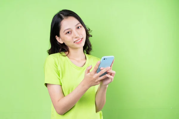 Imagem Jovem Mulher Asiática Segurando Smartphone Fundo Verde — Fotografia de Stock