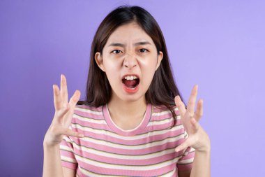 Güzel Asyalı kadın portresi, mor arka planda izole edilmiş.