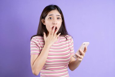 Güzel Asyalı kadın portresi, mor arka planda izole edilmiş.