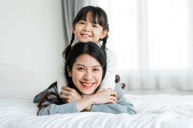 Yatakta Asyalı anne ve kız imajı