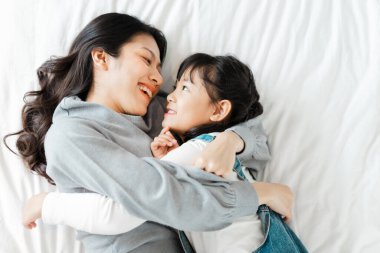 Yatakta Asyalı anne ve kız imajı