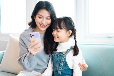 Anne ve kızının kanepede sarmaş dolaş olması.