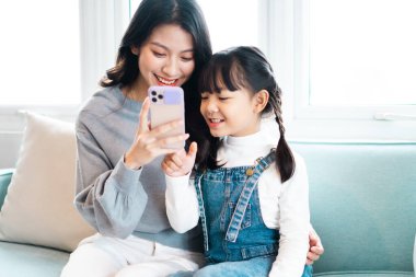 Anne ve kızının kanepede sarmaş dolaş olması.