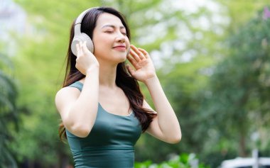 Parkta egzersiz yapan Asyalı kadın.