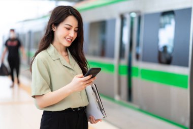 Asyalı iş kadını trende telefon kullanırken görüntüsü