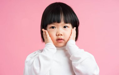 Güzel bir bebek portresi, pembe arka planda izole edilmiş.