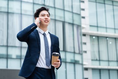 Cam bina geçmişine sahip Asyalı genç iş adamının görüntüsü