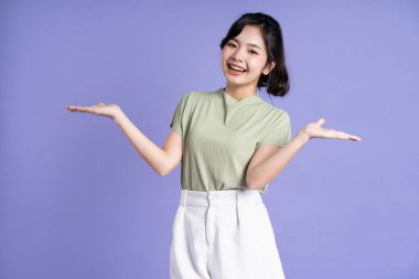 Mor arka planda poz veren güzel Asyalı kız portresi