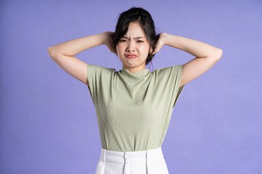 Mor arka planda poz veren güzel Asyalı kız portresi