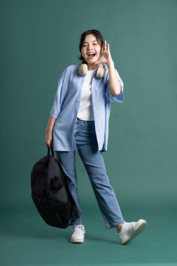 Yeşil arka planda güzel bir Asyalı öğrencinin portresi.