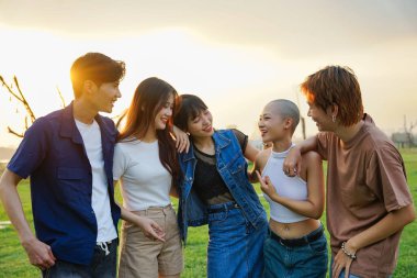 Birlikte mutlu bir şekilde gülen bir grup Asyalı 'nın resmi.