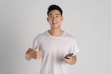 Beyaz arka planda poz veren Asyalı bir adamın portresi