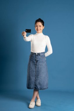 Mavi arka planda poz veren güzel bir Asyalı kadın resmi