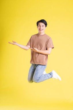 Portrait of asian man posing on yellow background clipart