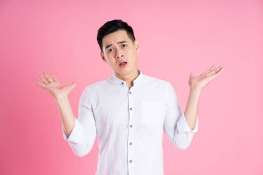 Pembe arka planda poz veren Asyalı adamın portresi