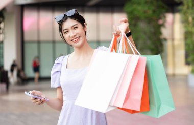 Alışveriş merkezinde mutlu Asyalı kadın alışverişi