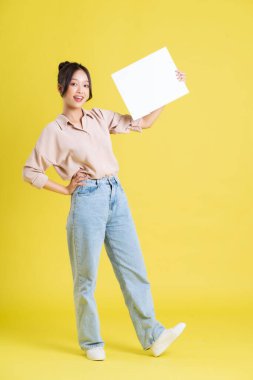 Beyaz reklam panosu tutan güzel bir Asyalı kız resmi.