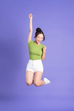 Pembe arka planda poz veren güzel Asyalı kızın tüm vücudu.